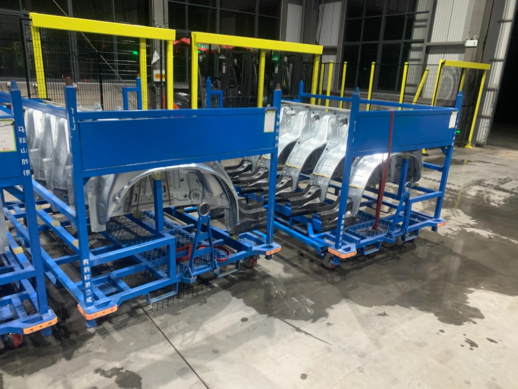 Dual blue steel parts racks with protective Isolation Liners on factory floor